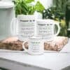 Three Stepped Up Dad Mugs featuring a witty definition in black and green text are arranged on a white table next to green plants and wooden decor.