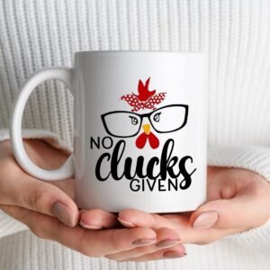 A person in a white sweater holds the No Clucks Given Mug, which features a cartoon chicken wearing glasses and a red bandana, with the text No clucks given.