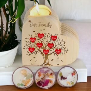 The Custom Family Tree Tea Light Holder with 3 Pack Tea Lights features a heart shape, Our Family engraved above a tree with red heart-labeled branches for names, and three tea lights decoratively placed in front.