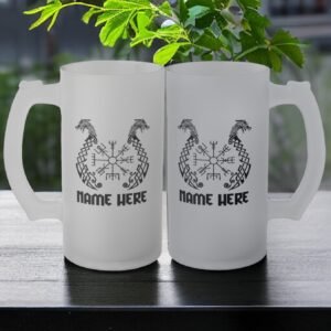 Two Viking Dragon Boat Frosted Glass Beer Mug Personalised rest on a dark table, each with dragon designs, runic symbols, and NAME HERE below. A green plant and an outdoor background complete the scene.