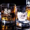 Engraved Photo Whiskey Glass Two Engraved Photo Whiskey Glasses with drinks: the left glass features a custom image of a man carrying a child and the names Dad & Daniel; the right reads Happy Father’s Day, Love Luke with an etched man holding a child.