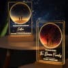 The Custom Night Sky Night Light features two illuminated acrylic plaques on wooden bases, displaying a starry sky and two silhouettes. Personalize each with names, messages, and dates to create a uniquely meaningful gift.