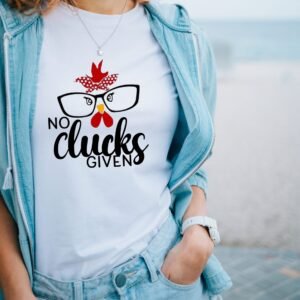 A woman stands outdoors in a light blue jacket and jeans, wearing the No Clucks Given Women’s Tee featuring a cartoon chicken face, red bandana, glasses, and the text “No Clucks Given” on a white Womens T-Shirt.