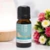 Aquarius Zodiac Essential Oil Blend A 10ml (0.34 fl. oz) bottle of Aquarius Zodiac Essential Oil Blend rests on a white surface beside colorful flowers and a wooden diffuser.