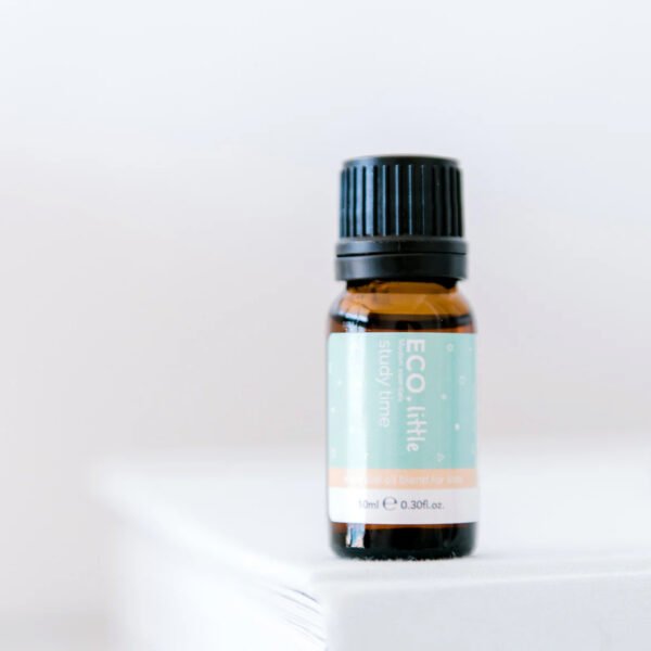 A small amber glass bottle with a black cap labeled ECO Little Study Time Essential Oil Blend is placed on a white surface against a blurred white background.