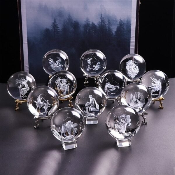 Laser Engraved Zodiac Crystal Ball Twelve glass or crystal balls, each engraved with a different zodiac sign, are arranged on stands in front of a misty forest backdrop.
