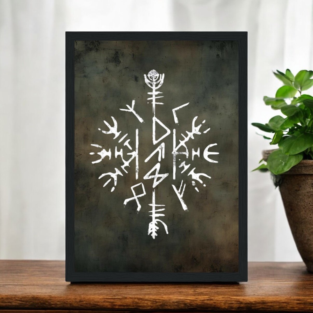 The Viking Stave For Dad Wooden Framed Print features a white abstract Viking stave symbol on a dark textured background, displayed beside a potted plant—making it the perfect gift for Dad.