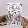 A book titled Spell Jars with an illustrated cover showing colourful jars filled with herbs, crystals, a lit candle, scrolls, feathers, and various magical items, set against a neutral background with rocks and acorns.