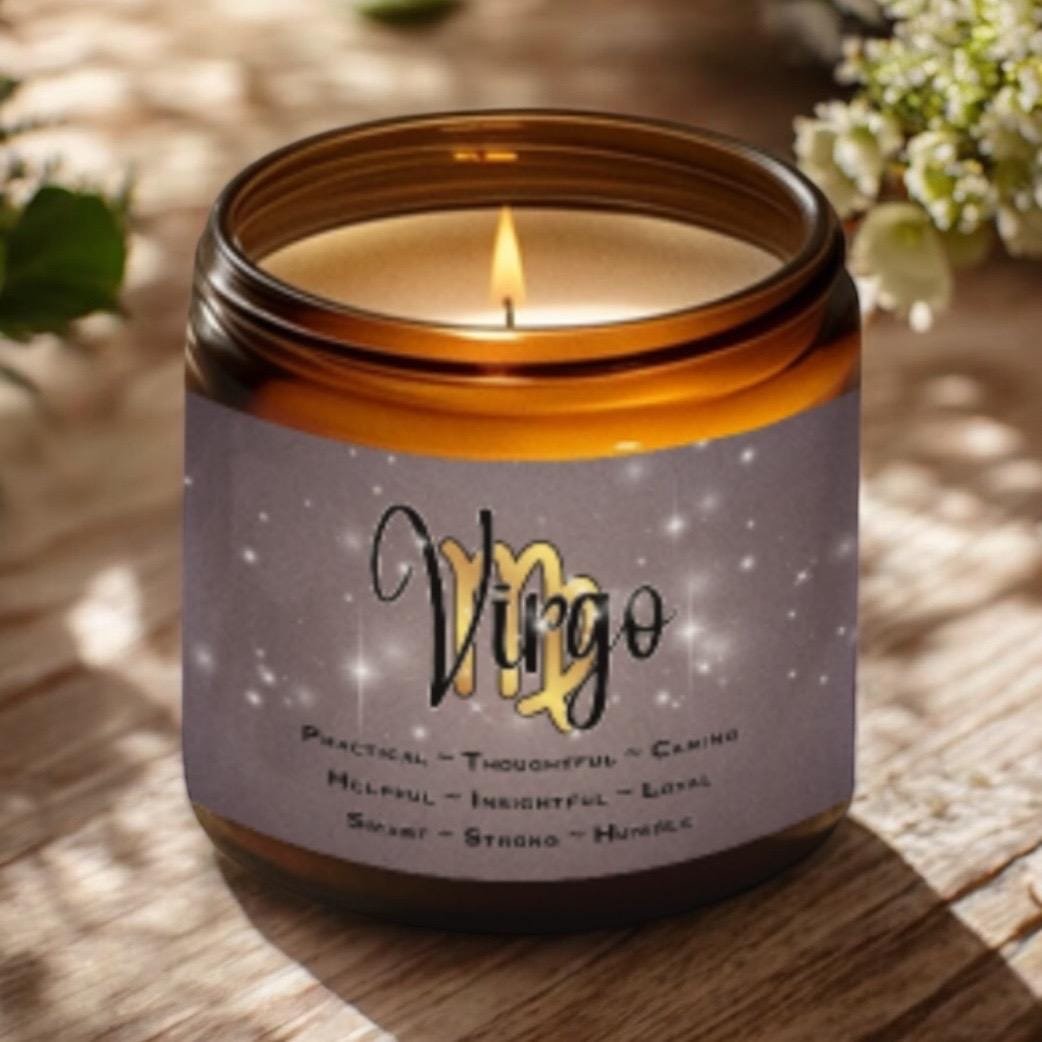 A lit brown glass candle sits on a wooden surface. The label reads Virgo with descriptive words below, including practical, thoughtful, caring, helpful, insightful, loyal, smart, strong, and humble. Flowers are in the background.