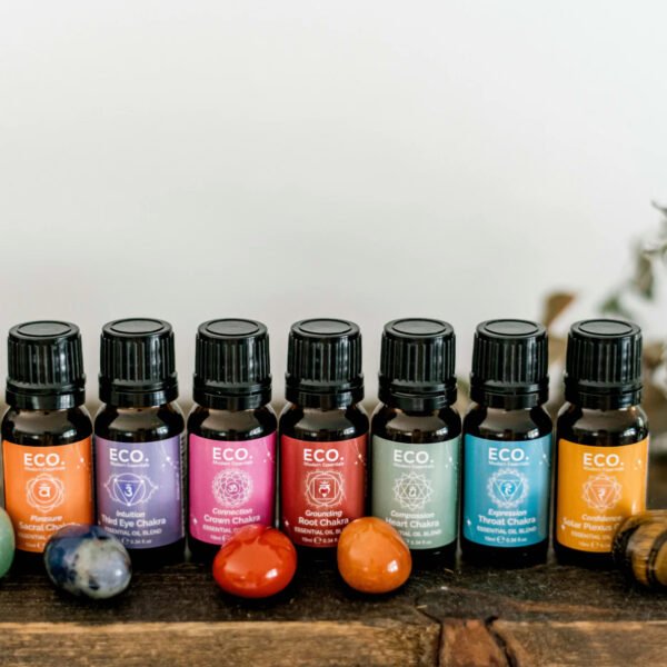 Chakra Essential Oil Blends Collection – 7x10ml Oils + Chakra Guide The Chakra Essential Oil Blends Collection – 7x10ml Oils + Chakra Guide is displayed on a wooden surface with colorful gemstones in front and blurred greenery in the background, creating a serene setting for your chakra rituals.