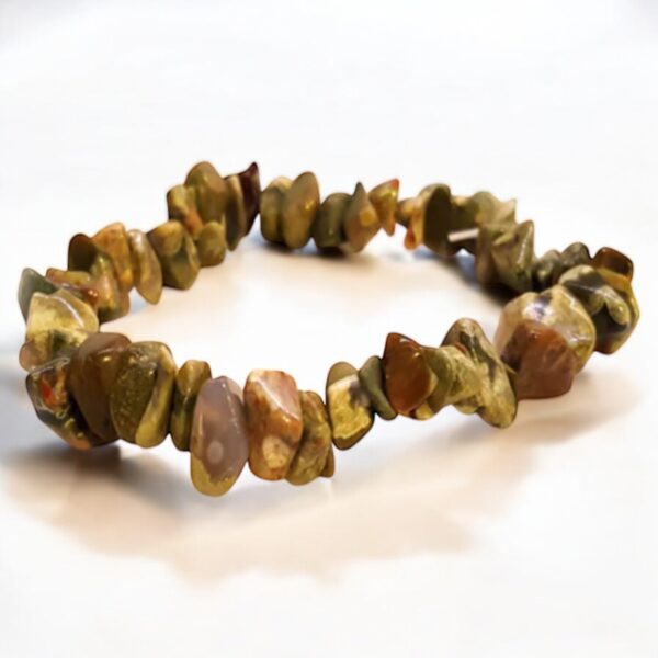 Rhyolite Chip Bracelet – Healing Crystal Jewellery The Rhyolite Chip Bracelet – Healing Crystal Jewellery features polished, irregular brown and green stones on an elastic band. Displayed on a white surface, it is believed to have healing properties.