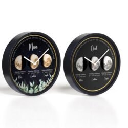 Two round wall clocks display personalized moon phases for “Mum” and “Dad,” with names, dates, and phases labeled beneath moon images. The “Mum” clock has a leafy design, while the “Dad” clock has a plain black background.