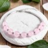 Sterling Silver & Rose Quartz Bead Bracelet Natural Rose Quartz beads on a sterling silver bangle bracelet. The bracelet is displayed laying on a white stone